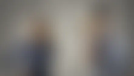 Dos personas usan teléfonos de lata, luciendo confundidas. Fondo gris con signos de interrogación. Ella lleva camisa azul, él camisa clara.