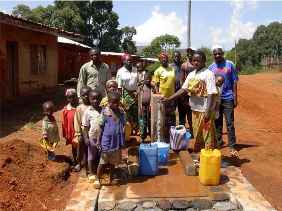 Las familias de una comunidad de Camerún se reúnen alrededor de la nueva llave de agua instalada por el Catholic Engineering Corps. (Foto proporcionada)