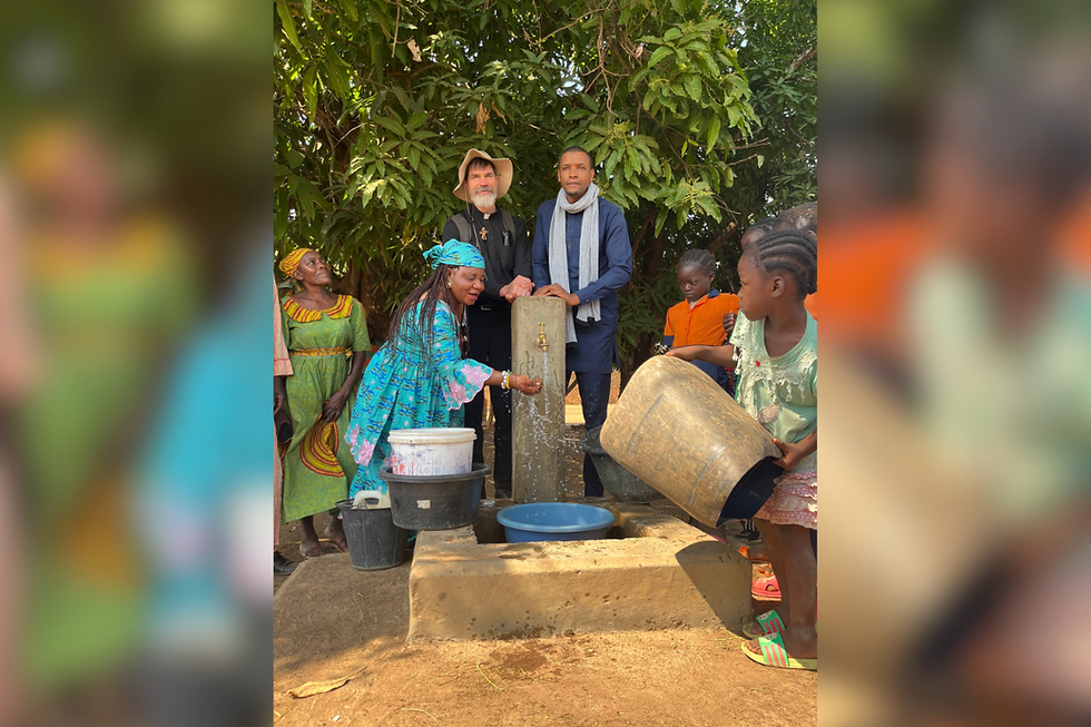El diácono Joshua Knight posa junto al más reciente proyecto de agua concluido en Bandam, Camerún. (Foto proporcionada)