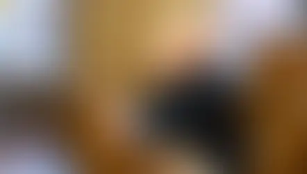 Dos hombres con vestimenta religiosa rezan en un banco de iglesia con vitrales coloridos en el fondo. Ambiente solemne.