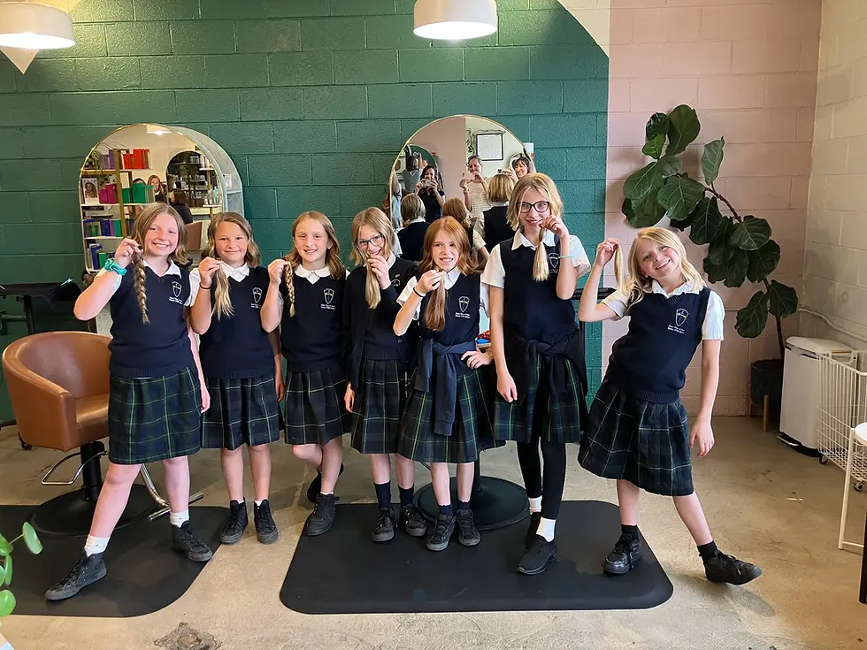 Estudiantes de la Escuela Católica STEM de Sts. Peter and Paul sonríen para una foto con las coletas que se cortaron para apoyar a otras personas con pérdida de cabello. (Foto proporcionada)