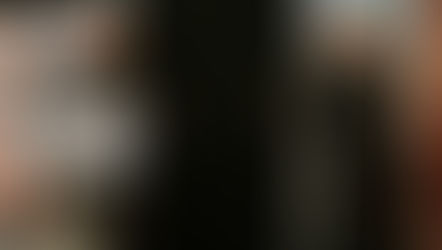 Dos sacerdotes, uno hablando en un podio y otro sonriendo, rodeados de imágenes religiosas en el fondo. Ambiente alegre.