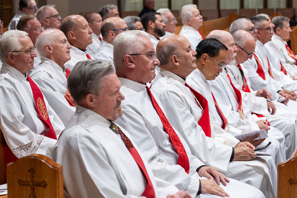 Hombres mayores con túnicas blancas y estolas rojas, sentados en silencio en una iglesia, con gesto solemne.