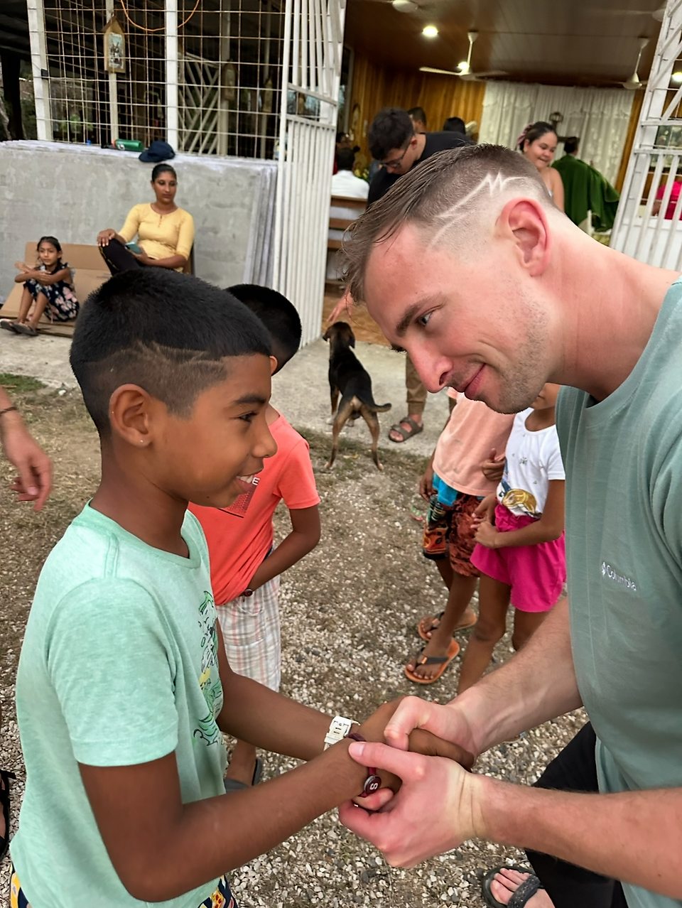 Will Ives le estrecha la mano a un niño durante un viaje misionero a Costa Rica.