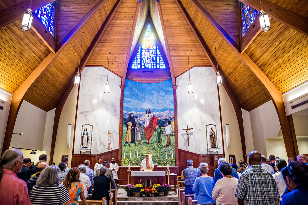 Congregación de pie en misa dentro de una iglesia de madera, con altar, sacerdote, crucifijo y mural de Jesús.