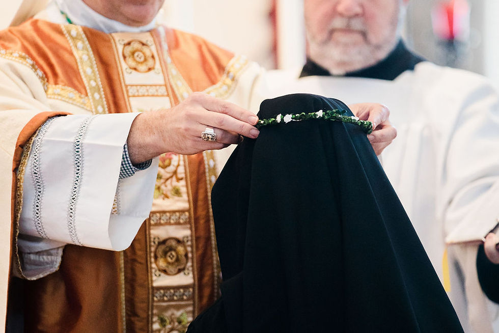 El obispo Stephen Lopes, del Ordinariato Personal de San Pedro, coloca una corona floral sobre la cabeza de la hermana Maria-Benedicta como parte de la liturgia de la profesión solemne. (Foto: Grant Whitty/El Pueblo Católico)