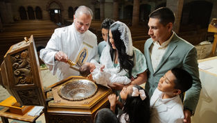 Bautizo en iglesia: sacerdote vierte agua sobre un bebé mientras la madre, el padre y niños observan con emoción.
