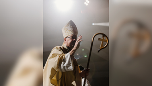 Sacerdote con mitra y báculo dorado en una ceremonia. Luz brillante detrás, ambiente solemne. Viste ropa litúrgica beige.