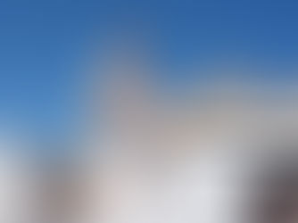 El papa sonriente saluda desde un vehículo blanco en la Plaza de San Pedro, con la basílica al fondo y cielo azul.