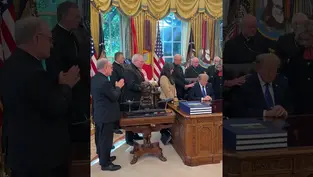 Trump reza en el Despacho Oval con varios obispos; fondo con cortinas doradas y banderas.