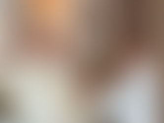 Tres clérigos en una iglesia se dan la mano durante una ceremonia, con vestimentas blancas y mitra beige; ambiente solemne.