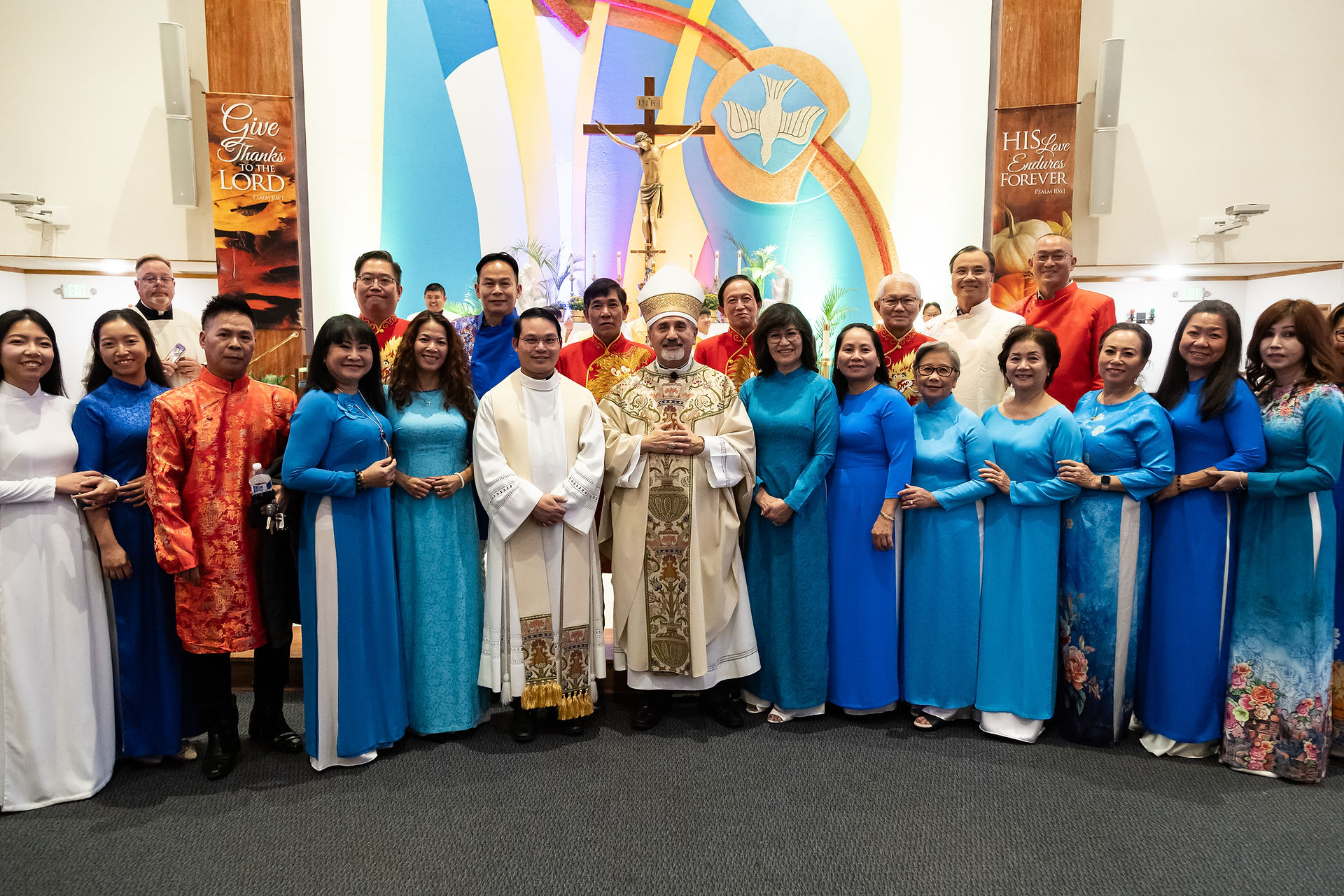 El coro vietnamita posa sonriente con el obispo Jorge después de Misa.