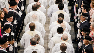 Procesión religiosa en una nave: hombres de blanco avanzan entre guardias con espadas y boinas negras, en un ambiente solemne.