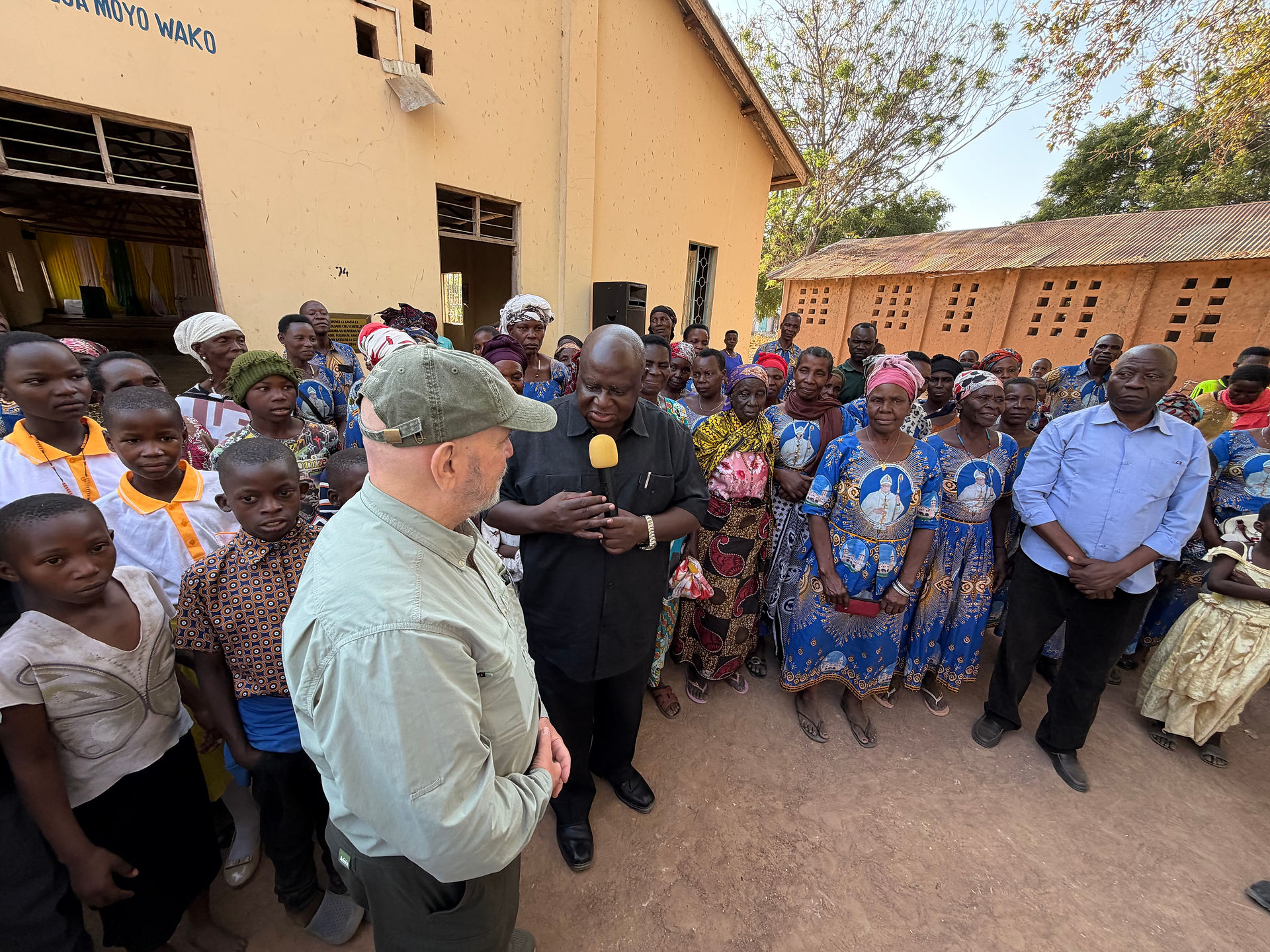 El padre George Nkombolwa, párroco de Kristo Mfalme, introduce al arzobispo emérito Samuel.