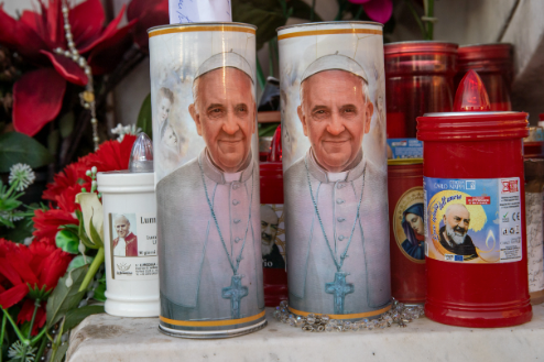 Velas con la imagen del papa Francisco afuera del hospital Gemelli en Roma el 21 de febrero del 2025. (Foto: Daniel Ibañez/CNA)