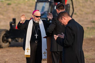El arzobispo Samuel Aquila reza junto con el padre Jason Wunsch (izquierda) y el padre Thomas Schere