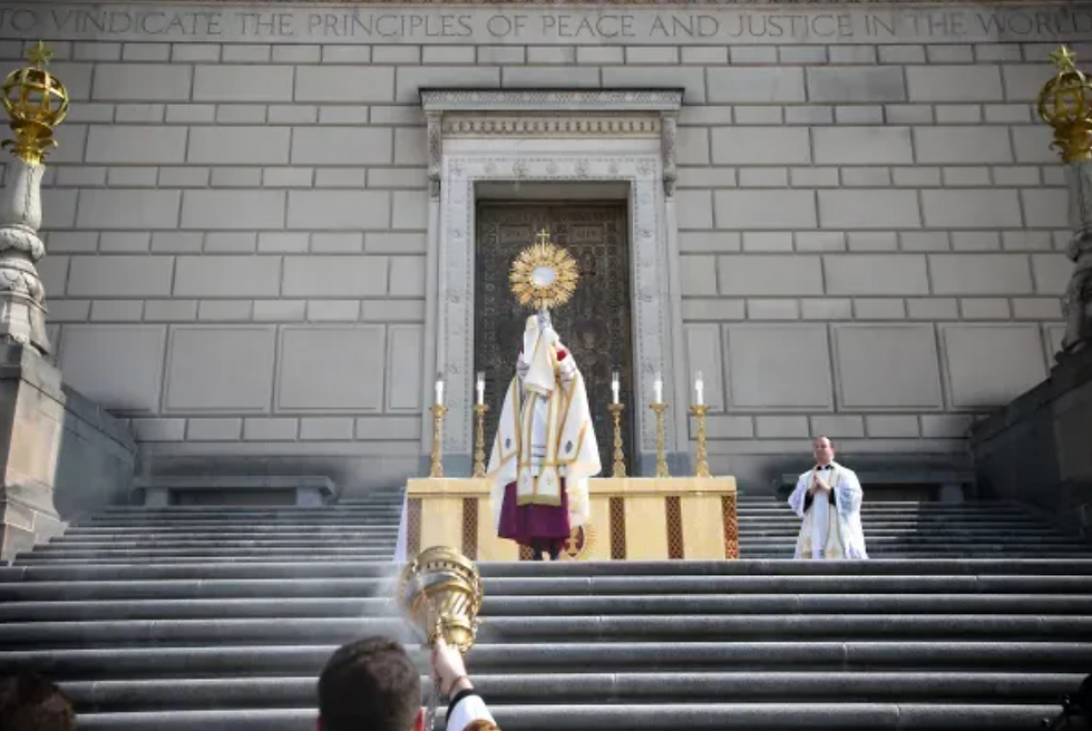 El obispo Cozzens con el Santísimo Sacramento ante el Indiana War Memorial. Crédito: Jeffrey Bruno