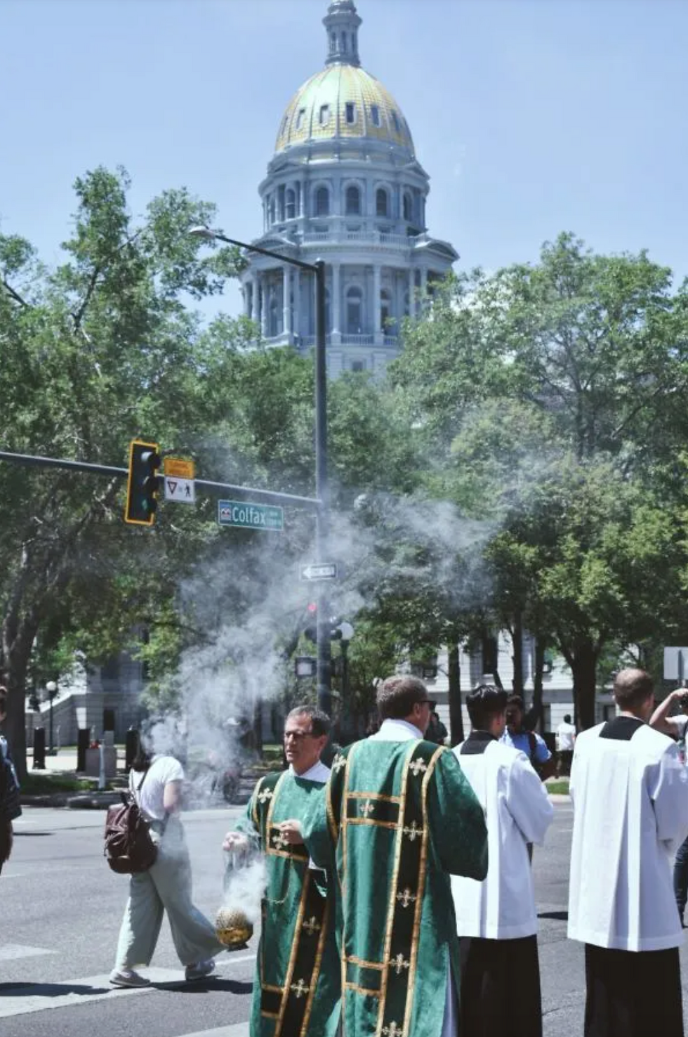 Un diácono esparce incienso durante la procesión eucarística, frente a la custodia, mientras otro sacerdote le guía frente al capitolio del estado de Colorado el 9 de junio de 2024. Crédito: Kate Quiñones/CNA