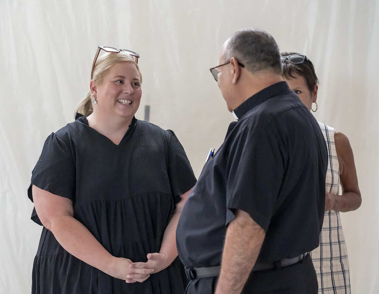 La Dra. Kemmery Hill, superintendente de escuelas católicas, habla con padre Martin Frias, párroco d