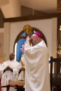 El arzobispo Samuel J. Aquila reza durante la misa en la parroquia Most Precious Blood de Denver. (Foto de Martin Jernberg)