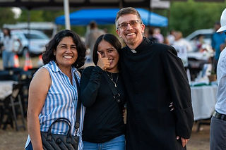 El padre Jason Wunsch (derecha) con feligreses durante una ceremonia de inauguración para la nueva i