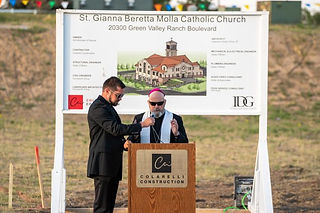 Padre Jason Wunsch reza con el arzobispo Samuel Aquila durante una ceremonia de inauguración para la